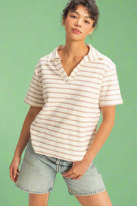 Model is wearing a cream collared short sleeve shirt 