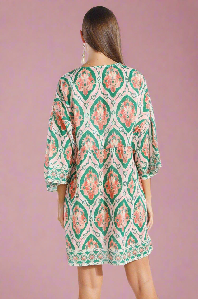 Woman wearing a patterned dress on a white background