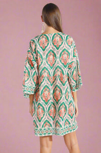 Woman wearing a patterned dress on a white background