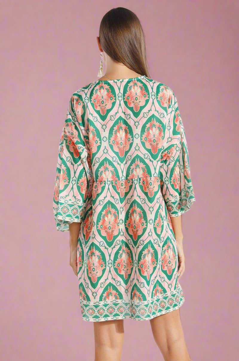 Woman wearing a patterned dress on a white background