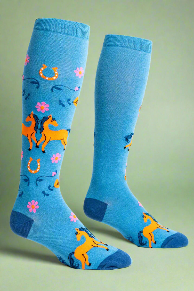 Pair of blue knee-high socks with horse and flower pattern on a white background