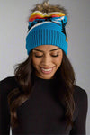 Woman wearing a colorful beanie with a gray background