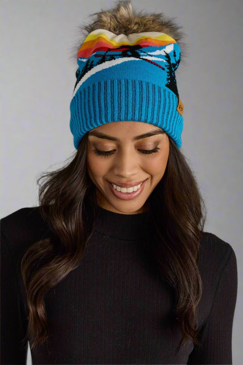 Woman wearing a colorful beanie with a gray background