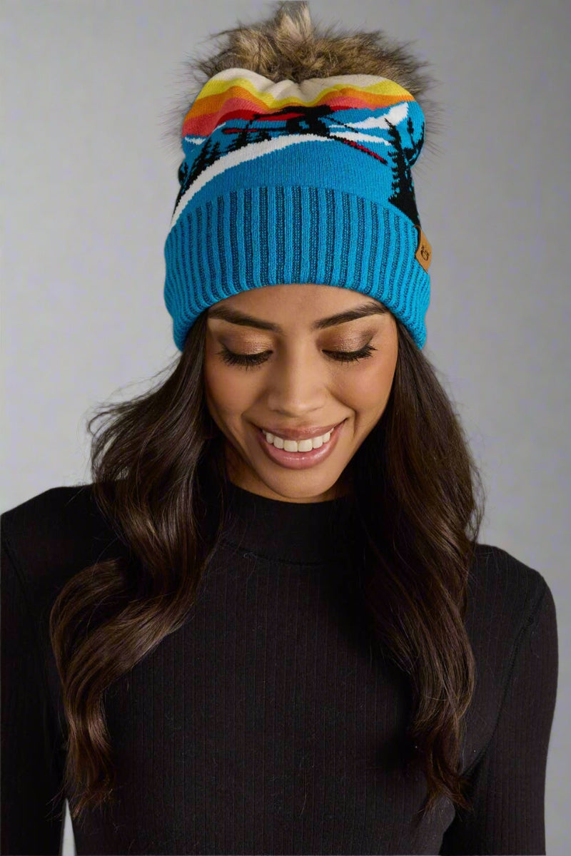 Woman wearing a colorful beanie with a gray background