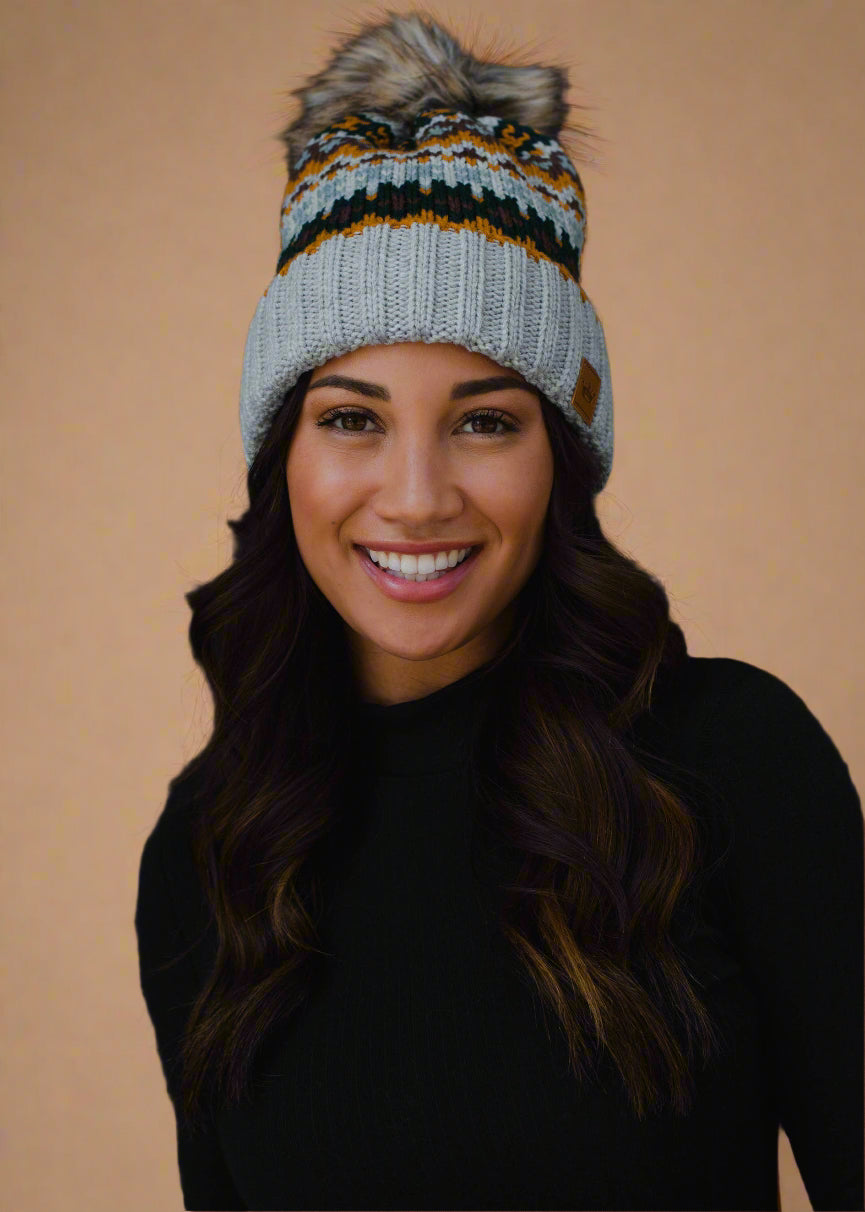 Woman wearing a colorful knit beanie against a black background