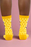 Yellow socks with black patterns worn by a person on a white background