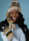 Woman wearing a patterned beanie and mittens against a black background