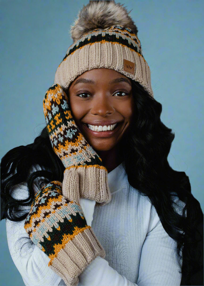 Woman wearing a patterned beanie and mittens against a black background