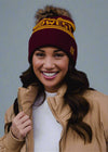 Woman wearing a maroon and gold beanie with 'Bow West' text against a black background