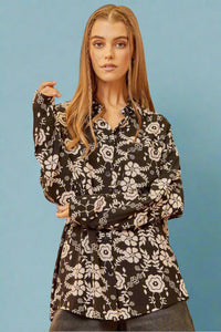 A long sleeve button up collared top in a black and white floral pattern.