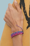 Shades of blue woven bracelet with wave pattern and adjustable slider and small silver 4ocean charm. 