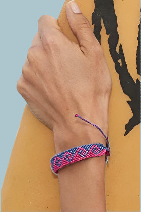 Shades of blue woven bracelet with wave pattern and adjustable slider and small silver 4ocean charm. 