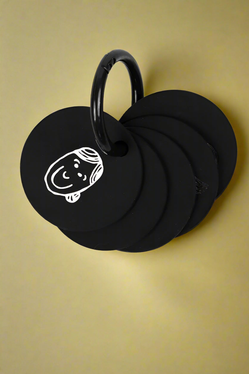 A set of black silicone discs depicting different facial expressions. 