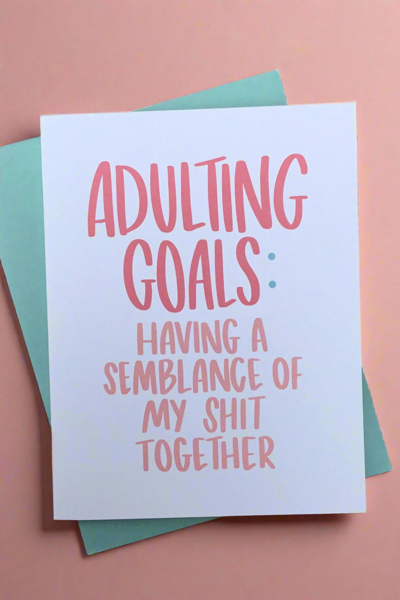 White card with pink words “Adulting goals: Having a semblance of my shit together.“