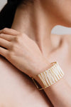 Adjustable gold cuff bracelet with raffia detailing. 