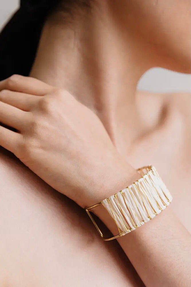 Adjustable gold cuff bracelet with raffia detailing. 