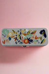 A navy blue tin container for pencils or whatever else you may want to store with latching lid covered in a floral pattern.