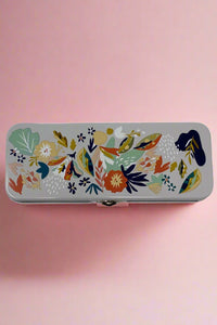 A navy blue tin container for pencils or whatever else you may want to store with latching lid covered in a floral pattern.