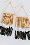 These black, gold, and white beaded earrings have gold accents. 