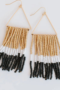 These black, gold, and white beaded earrings have gold accents. 