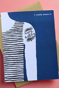 A blue greeting card with an illustration of half of someone’s torso and arm with tattoo of happy birthday and the text ‘I really mean it’.