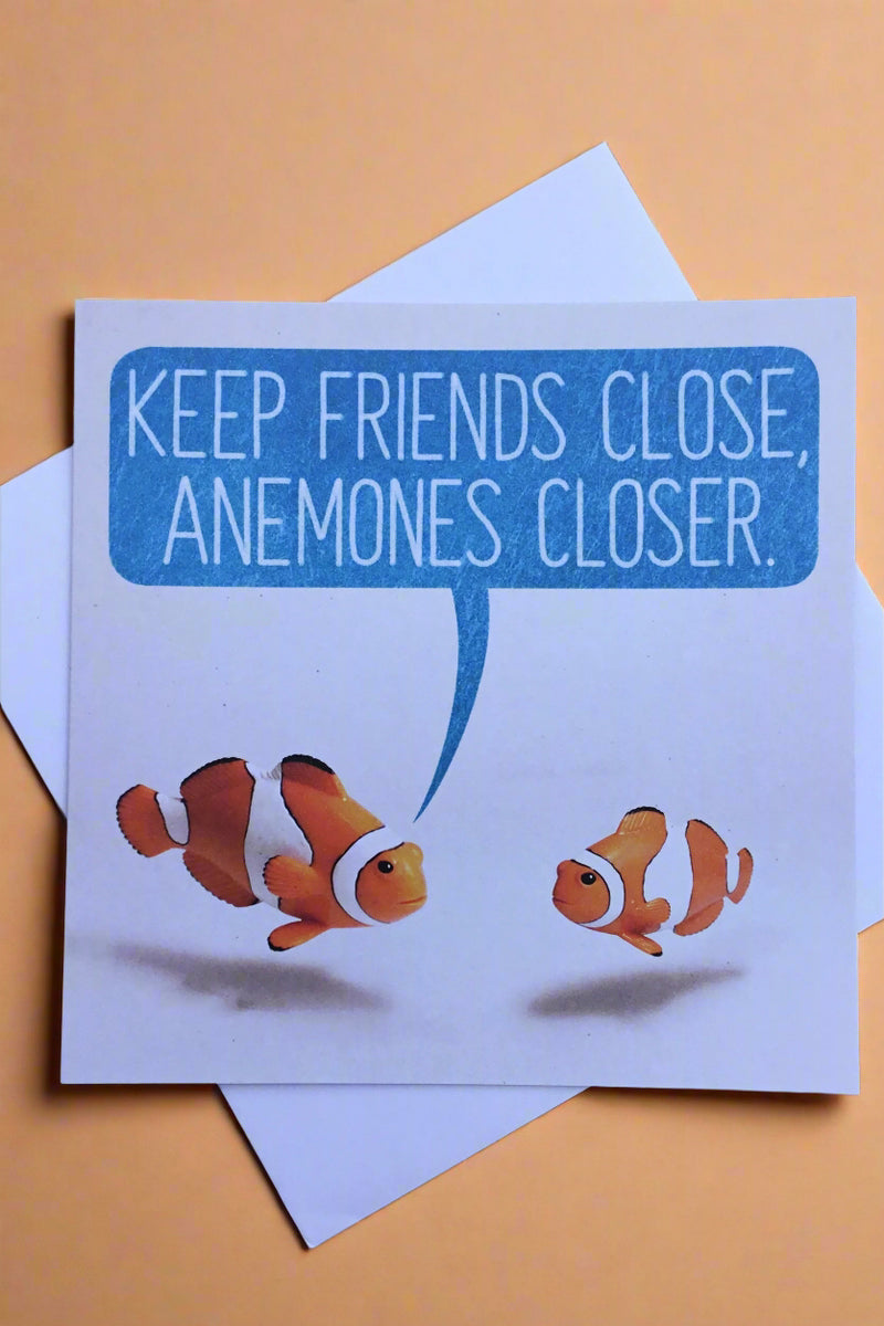 A square card with two clown fish and a word bubble that says “Keep friends close, anemones closer.”