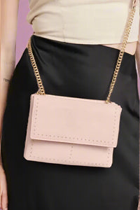 Gold flap style crossbody with dainty gold stud detailing around the perimeter of the front panels. Gold chain for strap with a pink shoulder pad for comfort. 