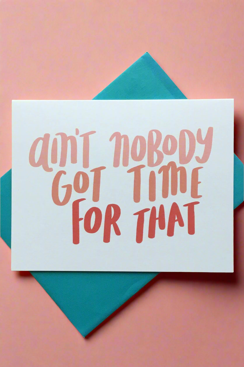 A simple white greeting card with pink text that reads ‘ain’t nobody got time for that’.