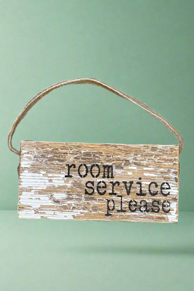 A distressed wood hanging sign that has “Room Service Please” written on the front.