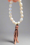 This gorgeous bracelet is made with stretchy elastic and features delicate pearl beads and a genuine leather tassel.