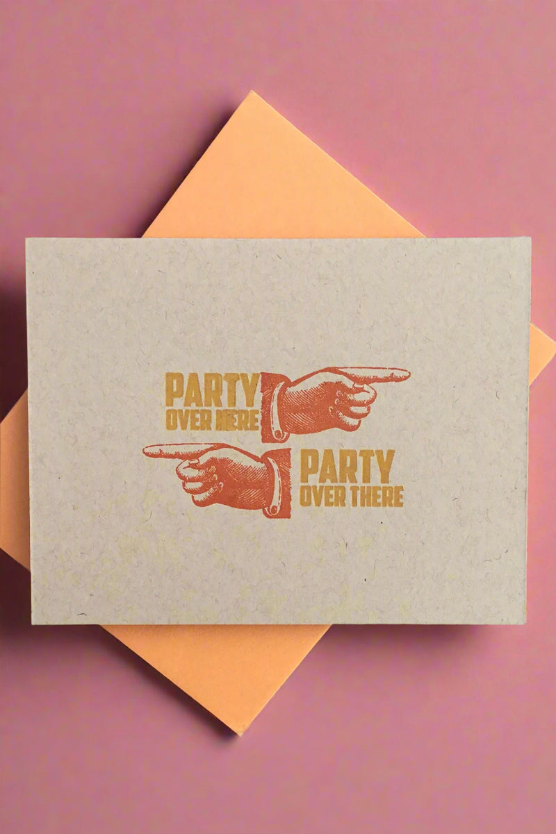 A greeting card with the image of a hand pointing right and text that says ‘party over here’ as well as an image of a hand pointing left and text that reads ‘party over there’.