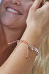 An adjustable orange and clear bead bracelet with pelican charm.