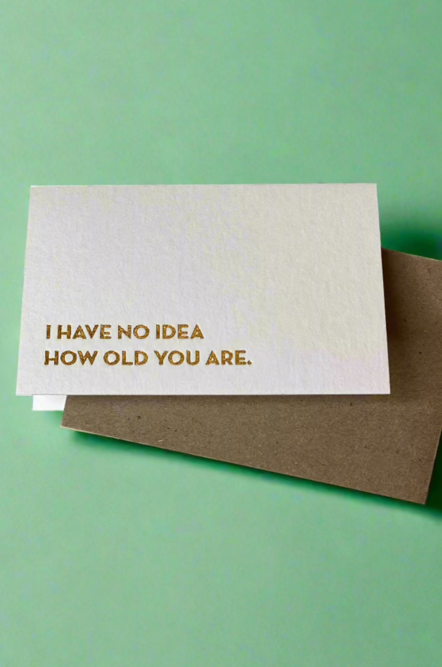 A minimalist style mini greeting card with gold foil text that reads ‘I have no idea how old you are.’