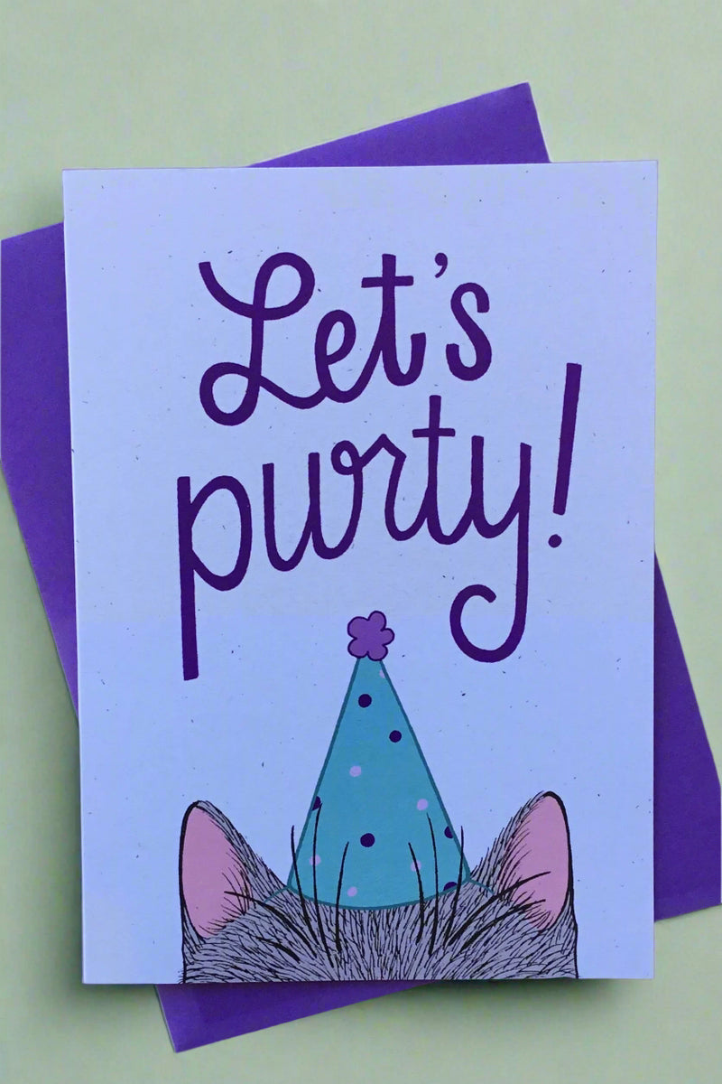 A greeting card with the illustration of the top of a cats head wearing a cone birthday hate and text above that reads ‘Let’s Purty!’