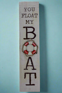 A vertical rectangle sign that says “You Float My Boat.”