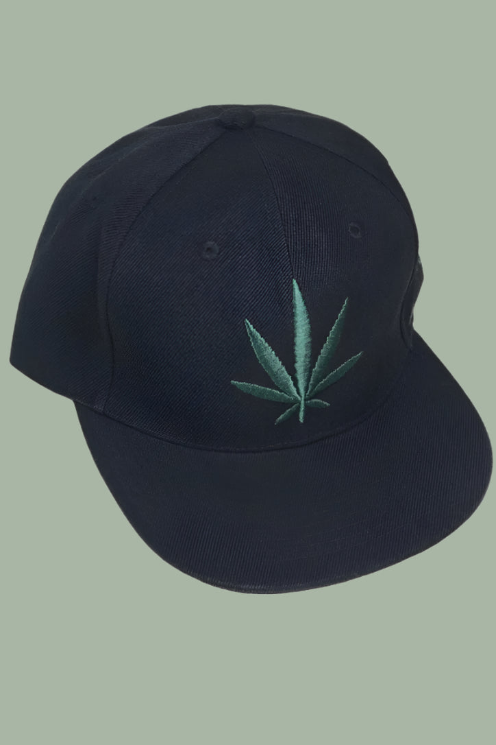 Black adjustable baseball cap with a green pot leaf embroidered on the front panel. 
