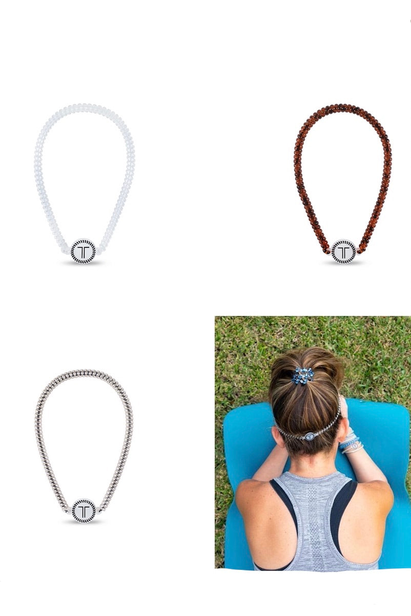 Coiled, athletic headbands showcased in four different colors: Crystal Clear, Tortoise, Platinum, and Sunset Gold.