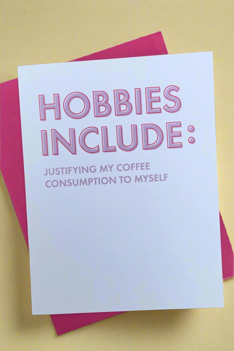 A white card with “Hobbies include: Justifying my coffee consumption to myself.” written in pink letters.