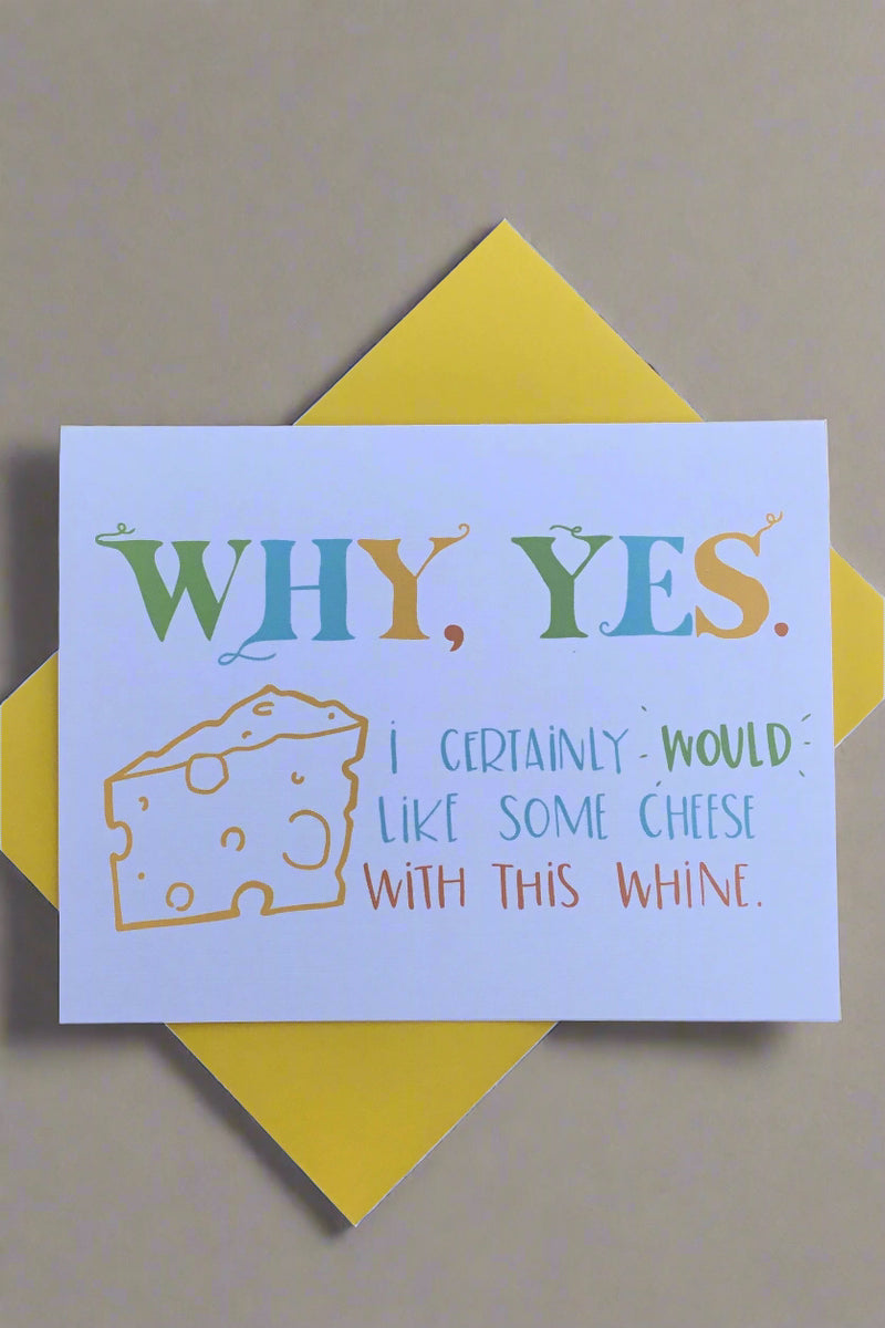 A white card with an image of a cheese triangle that says “Why, yes. I certainly would like some cheese with this whine.”