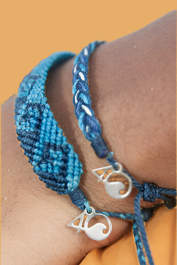Shades of blue woven bracelet with wave pattern and adjustable slider and small silver 4ocean charm. 