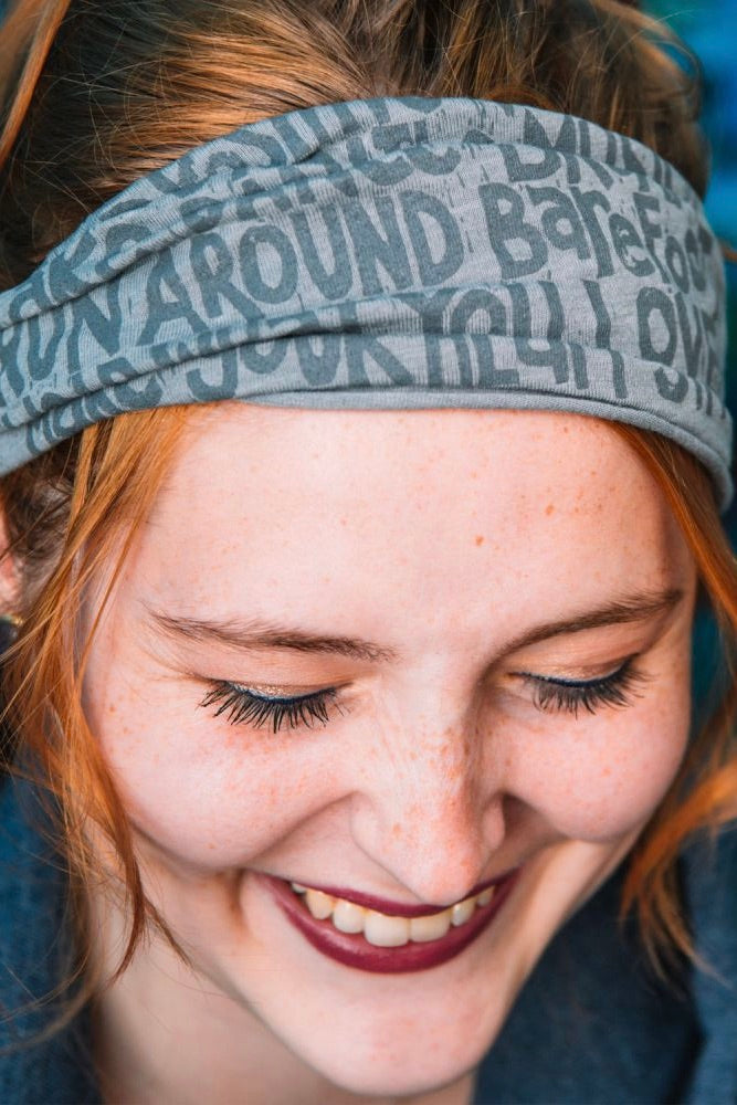Soft light grey headband with a "manifesto" printed on it in a contrasting grey. 