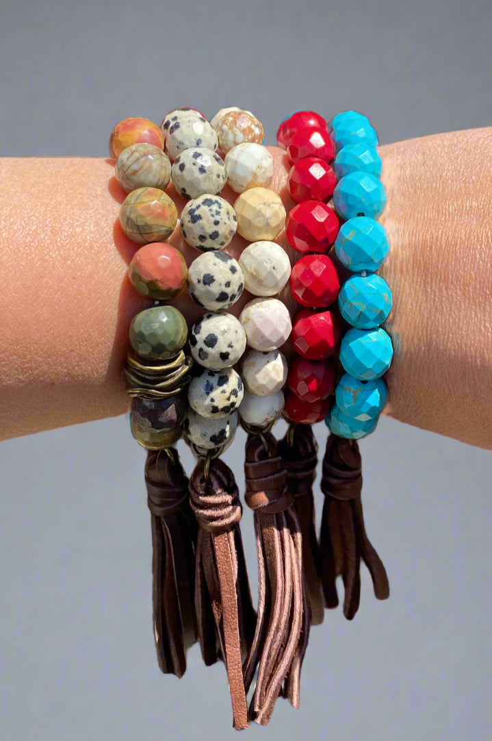 Layer up these elastic bracelets with square cut beads. One birds nest bead and real leather tassel. Handmade in Dallas by mother and daughter team.