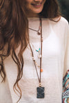 Boho style layered necklace. Each layer is a different length and material featuring unique stone and shell beads. 