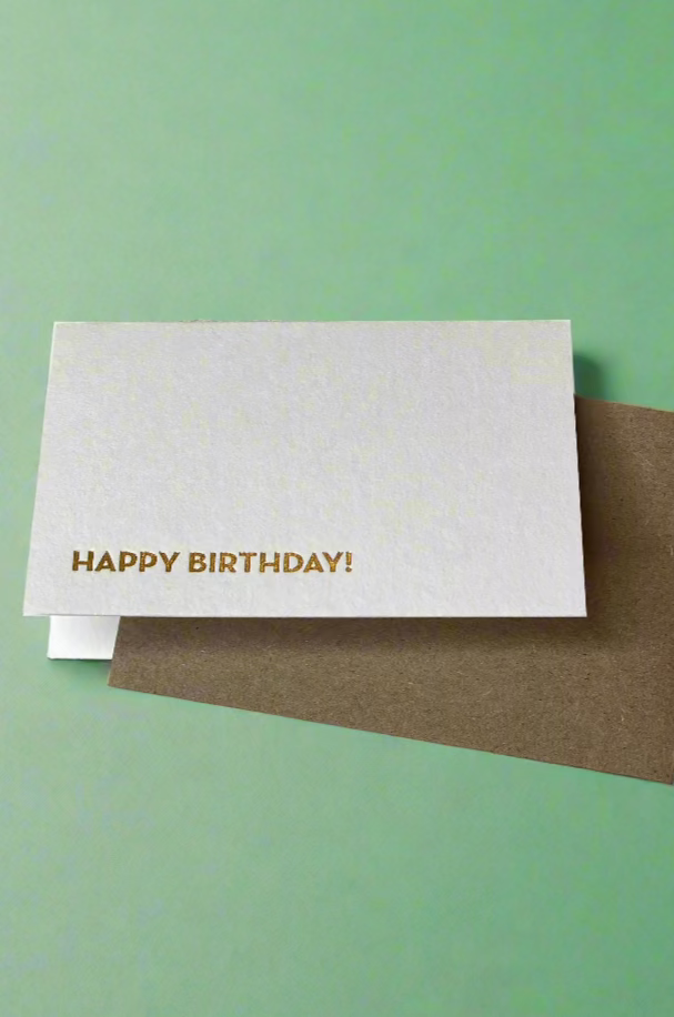 A minimalist tiny greeting card in white with text that reads ‘Happy Birthday!’