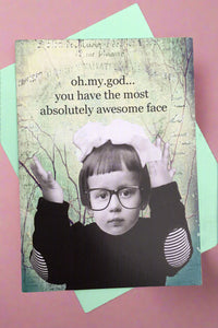 A greeting card with a black and white image of a serious-faced child with glasses on and black text that reads ‘oh.my.god… you have the most absolutely awesome face’.