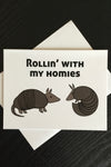 An off white card fe two armadillos and says “Rollin’ with my homies.”