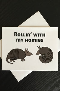 An off white card fe two armadillos and says “Rollin’ with my homies.”