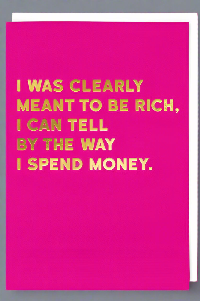A hot pink card with the words “I was clearly meant to be rich, I can tell by the way I spend money.”