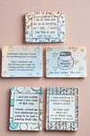 A photo of 5 different reusable cleaning cloths with funny sayings on them.