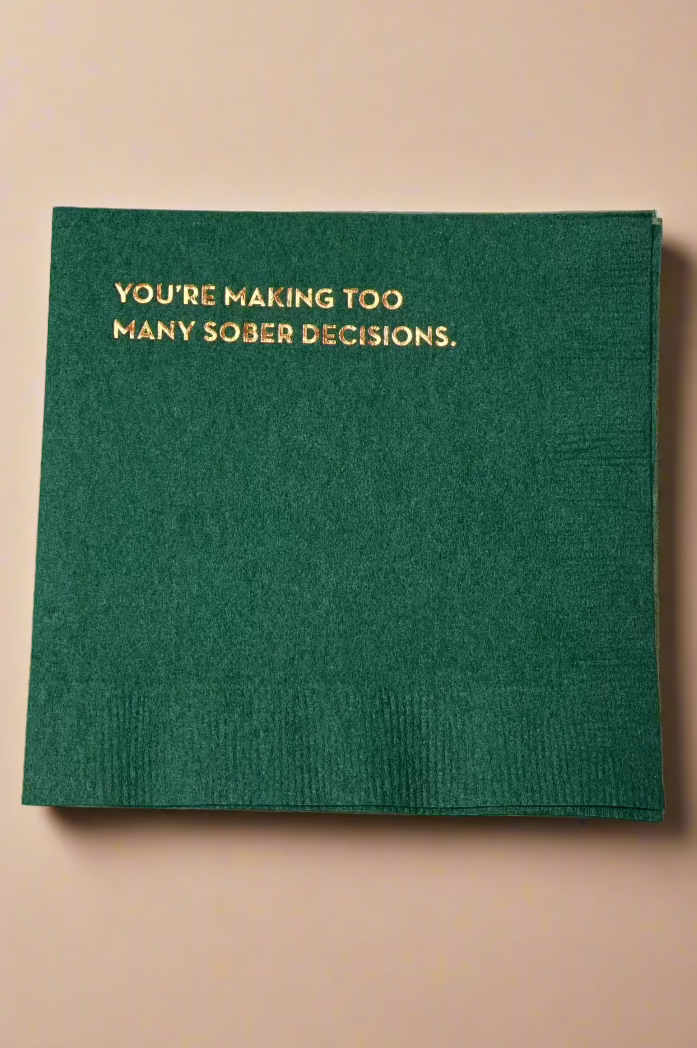 A green cocktail napkin that has ‘You’re Making Too Many Sober Decisions’ on it.